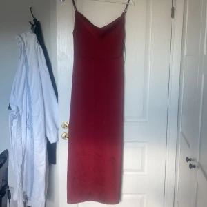 Vinröd långklänning från Vila - Säljer en elegant vinröd långklänning från Vila med smala axelband och mjukt draperad urringning. Klänningen har en stilren, figurnära passform. Aldrig använd med prislapp kvar . Köpte för 460 kr. 