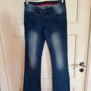 Lågmidjade bootcut jeans - Köpta second hand, någon har lagt ner jeansen så de har blivit längre (Bild 3&4). Och hål på insidan för att reglera midjans storlek, men det är inget som påverkar funktionen alls. Midjemått: 39,5 cm rakt över. Innerbenslängd: 81 cm. 