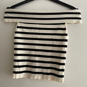 Randig offshoulder topp från H&M - Snygg offshoulder topp från H&M i XS med svartvita ränder. Stickad känsla och croppad passform som sitter tajt❣️köparen står för frakt!