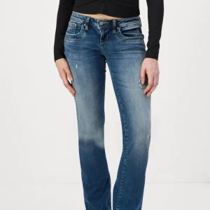 LTB Valerie blå bootcut jeans - Snygga blå jeans från LTB, modell Valerie, med bootcut och låg midja. Jeansen har slitna detaljer och klassisk femficksdesign. Materialet är mjukt denim i bomull med lite stretch för extra komfort. Perfekta för en avslappnad och trendig look.