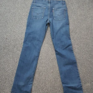 Levi's 511 blå slim jeans - Snygga blå Levi's 511 jeans med slim passform och klassisk femficksdesign. Jeansen har en rak siluett, normal midja och är tillverkade i mjukt jeanstyg. Storlek 158/164 Skick 8/10. Jeansen har dock en fläck på det vänstra benet som visas på sista bild. Fläcken bör dock gå bort vid tvätt eller vanish. Obs: jeansen ser mattare och färglösare ut än vad dem egentligen är, på bild 1 och 2.