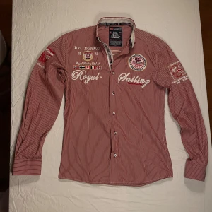 Skjorta David Hamilton🇳🇴 - Snygg röd och vit randig skjorta från David Hamilton Norway med broderade detaljer, flaggor och text på bröstet och ärmarna. Stor gul broderad siffra 3 på ryggen och norsk flagga. Långärmad, klassisk krage och knappar framtill. M men passar också S!