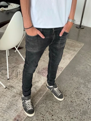 Svarta slim fit jeans från tiger of Sweden - Säljer ett par svarta slim fit jeans med lätt slitna detaljer och klassisk femficksmodell. Jeansen har smal passform och normal midja, perfekta till sneakers och t-shirt. Stretch- material för extra komfort. W30 L32