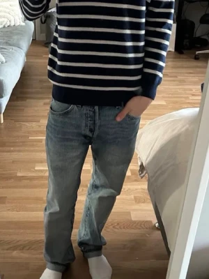 Blåvit randig tröja Uniqlo - Snygg randig blåvit tröja från Uniqlo i storlek XS. Tröjan har rund halsringning och ribbade muddar vid ärmslut och nederkant. Perfekt för dig som gillar klassisk och stilren look. Materialet känns mjukt och bekvämt mot huden.