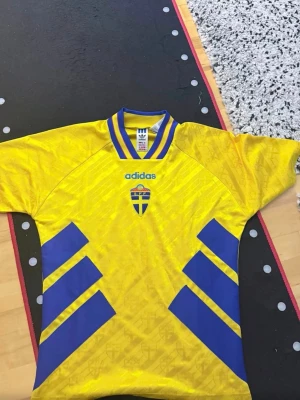 Svensk landslagströja 1994  - Nya versionen 1994 köpt på unisport för 1200. Exklusiv då den är slut i lager. Helt ny. Och säljs nu för 800. Storlek S men sitter även som slim fit M 