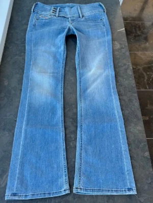 Ljusblå bootcut jeans - Säljer ett par ljusblå lågmidjade bootcut jeans Innerbenslängd: ca 81 cm, midjemått: ca 42 cm, midjehöjd: ca 20 cm