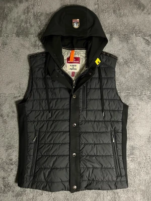 Parajumpers – Fleece & Puffer Hooded Vest (S) - Rare and high‑quality Parajumpers vest from the Fleece & Puffer line, featuring a hood with embroidered logo and multiple functional pockets. Size S, length 60 cm, pit‑to‑pit 51 cm – adjustable hood for a perfect fit.  ✅ Condition: Excellent – no visible wear or damage 💯 Authenticity: 100 % genuine, can be verified on certilogo.com   📦 Shipping: Fast dispatch after purchase  This vest combines Parajumpers’ technical design and premium materials — lightweight yet warm, stylish, and built to last.
