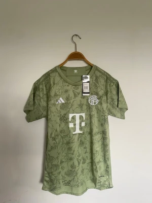 Grön Adidas fotbollströja M - Bayerns 2023 octoberfest tröja, helt ny med prislapp. PRISET KAN JUSTERAS 