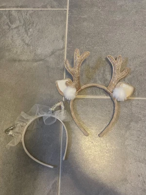 2-pack diadem med horn och öron - Säljer två diadem, ett med glittriga guldiga renhorn, vita öron och fluffiga bollar, samt ett med silvriga kattöron och vit tyll. Båda har mjuk textil och passar perfekt för temafester eller maskerad.