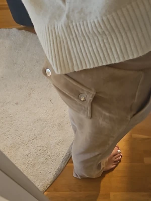Beiga Juicy couture byxor - Säljer ett par beiga juice couture byxor med raka ben och stora fickor på sidorna. Använt fåtal gånger, säljer dem då de inte passar mig lika bra längre.