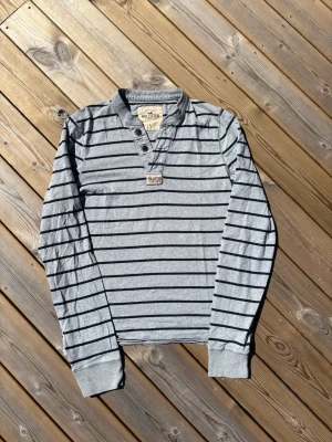 Hollister Henley ~ Sällsynt  - Säljer denna Hollister Henley i mycket bra skick och som är Sällsynt. Storlek L men kan passa M. Passar perfekt för dig som är mellan 175-180! Hör av er vid frågor eller minsta fundering 🙌  Längd: 66,5 cm  Bred: 49 cm Ärm: 72 cm