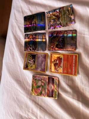 Samling Pokémonkort holografiska - Säljer en samling Pokémonkort med flera holografiska och färgglada motiv. Korten har olika Pokémon och attacker, vissa med gul ram och andra med helbild. Perfekt för dig som vill utöka din samling eller byta med vänner.