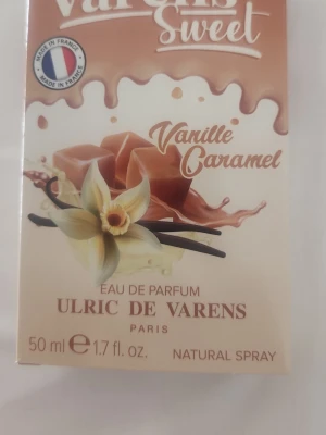 Varens Sweet Vanille Caramel parfym - Varens Sweet Vanille Caramel från Ulric de Varens är en Eau de Parfum med söt doft av vanilj och karamell. Flaskan är genomskinlig med beige etikett och har ett brunt lock. Innehåller 50 ml och kommer i en matchande förpackning med vaniljblomma och karamellmotiv.