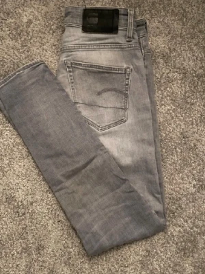 G-star Jeans  - Säljer ett par ljusgrå slim fit jeans från G-star Raw. storlek W29 L30. Har en liten slitning på knät som bara gör dem snyggare. Skriv vid intresse!