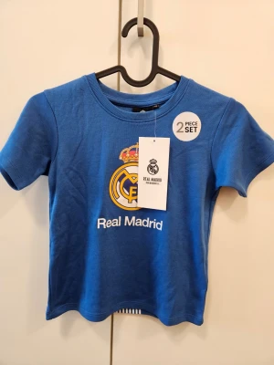 Real Madrid barnset - Storlek 110. Ny med lappar. Säljes då det var en present men jag råkade köpa fel lag. 60% bomull och 40% polyester. 