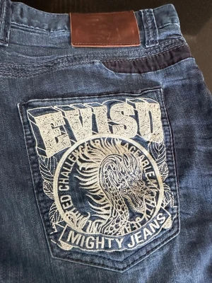 Blå jeans med drakbrodyr från EVISU - Säljer tvär feta vintage evisu köpta i Japan med drakbrodering på ena bakfickan. 