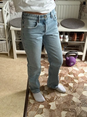 Ljusblå raka jeans från Zara  - Säljer ett par ljusblå jeans med rak passform och hög midja. Jeansen har klassiska fem fickor och stängs med knapp och dragkedja. Perfekta till en avslappnad stil och passar till det mesta. Materialet är denim i bomull.