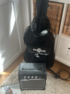 Elgitarrpaket Gear4music vit - Säljer ett komplett elgitarrpaket från Gear4music med vit elgitarr, förstärkare, hörlurar och svart fodral. Gitarren har klassisk Stratocaster-form, tre single coil-mickar och vita reglage. Perfekt för dig som vill börja spela elgitarr.