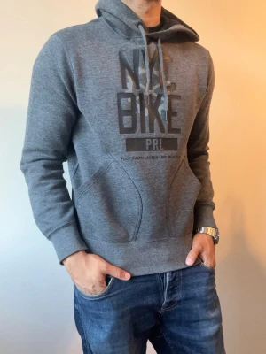 Svartgrå Ralph Lauren Hoodie - Säljer denna snygga Ralph lauren hoodie märkt med ”NYC BIKE” | Storlek S | Mycket bra skick | Modellen är 175cm, 70kg