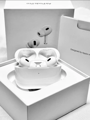 Apple AirPods Pro gen 2 trådlösa hörlurar - Säljer ett par vita Apple AirPods Pro med laddningsetui. Hörlurarna har en stilren och kompakt design med silikonproppar för bra passform. Perfekta för musik, samtal och träning. Levereras i originalförpackning.