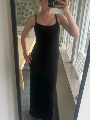 Svart långklänning med smala axelband - Säljer en svart maxidress med smala axelband och figurnära passform. Klänningen har en enkel och stilren design som passar perfekt till olika tillfällen. Materialet känns mjukt och följsamt mot kroppen. För preferens är jag 176 och den är bra längd på mig. Pris kan komma att diskuteras. 
