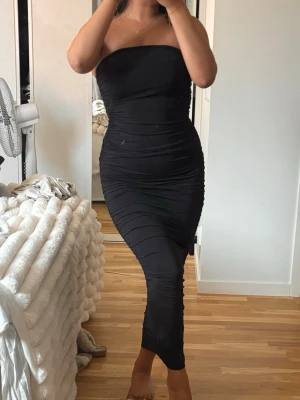 Svar tub klänning  - Svart super fin svart klänning med scrunch på båda sidorna för att framhäva kroppen! Klänningen är super stretchig men i ett tjock lyxigt tyg. Klänningen är köpt på bershka eller Zara för måååånga år sedan men aldrig kommit till användning!🤍 passar Xs/S och en xxs då den är så stretchig och anpassar sig på kroppen 