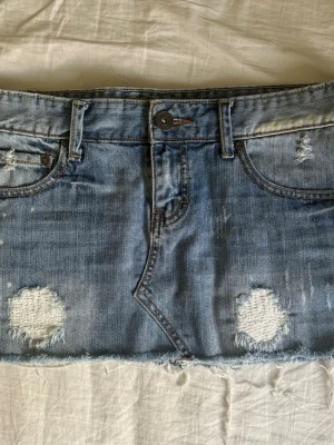 Jeanskjol - Lågmidjad jätte fin blå jeanskjol från fishbone. Har en fläck där bak (kolla bild 2), den syns knapp❤️