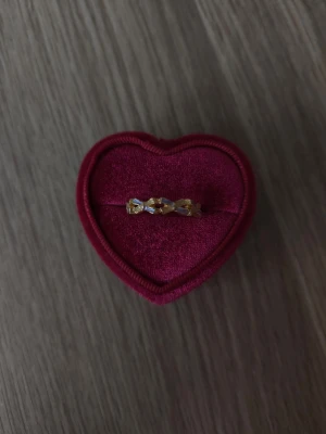 Guldfärgad ring med rosettdetaljer - Rosett ring i storlek 18,1mm, guldfärgad.