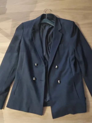 Mörkblå kavaj från Massimo Dutti - Stilren mörkblå kavaj från Massimo Dutti.        #baggyjeans #lowwaist jeans #cargobyxor #vida jeans #flarejeans #lågmidja #rakajeans #kostymbyxor #mjukisbyxor #oversizedhoodie #ziphoodie #stickadtröja #corsettopp #offshoulder #babytee #linne med spets #oversized tshirt #stickadväst #maxikjol #y2k #vintage #streetwear #oldmoney #cleangirl #basic #festkläder #vardagskläder #unisex #oversized #fitted #cozy #retro #zara #hm #bikbok #ginatricot #nelly #nakd