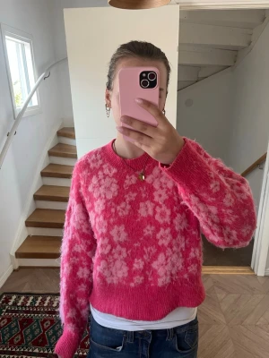 Rosa blommig stickad tröja - Fluffig stickad tröja i stark rosa med ljusrosa blommönster, ganska kort modell