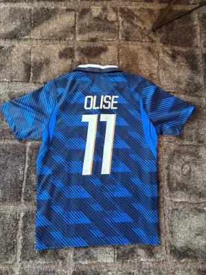  Frankrike borta fotbollströja Olise 11 - Säljer av lite feta fotbollströjor nu efter vm, Frankrike borta ställ med Olise på ryggen. Tröjan är använd 1-2 gånger och är i ny skick, storlek M! 