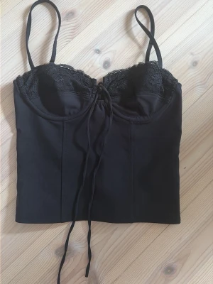 Svart korsett med spetsdetaljer -  Slutsåld Snygg svart topp/corsett från Gina tricot 14+