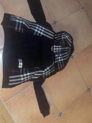 Burberry Kofta - Säljer en svart burberry kofta för 500kr i Göteborg. Koftan är stl S, men den är liten i storlek