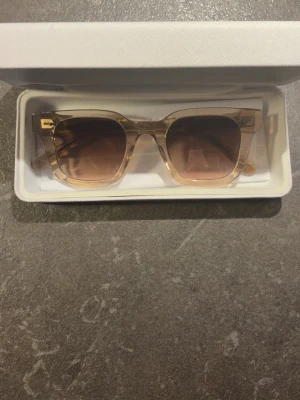 Beige fyrkantiga solglasögon CHIMI - Snygga solglasögon från CHIMI med transparent beige båge och fyrkantig form. Glasen har en mjuk brun toning som ger en modern vibe. Kommer i originaletui och box. Perfekta för dig som vill ha en clean och trendig look. (NYPRIS 1400) om man vill ha fler bilder på glasögonen så är det bara att höra av sig 😁