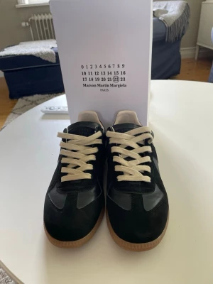 Maison Margiela svarta sneakers - Ett par riktigt snygga svarta maison margielas skor som passar till alla kläd stilar, allt från grish till archive. Jag säljer dom för att dom är lite för små. Dom är använda en gång och är i väldigt bra skick.