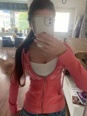 Korall rosa tajt Hollister zip hoodie med broderi - Gullig korallrosa zip hoodie med vit broderad hollister text över bröstet, strl M omsydd till xxs! Följ för mer liknande hollister och abercrombie zipups