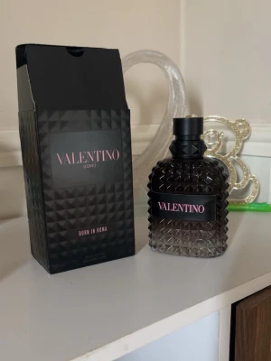 Valentino Uomo Born in Roma parfym - Säljer en Valentino Uomo Born in Roma parfym. Flaskan är mörk med nitar och har en lyxig, modern design. Svart och transparent glas med rosa text på etiketten. Kommer med originalkartong i matchande stil. Helt ny 100 ml ny pris 1080kr kan tänka mig gå ner lite för en snabb affär 