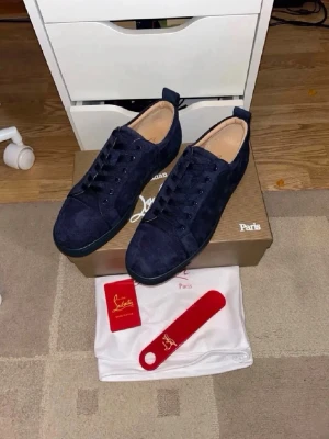Mörkblå sneakers från Louboutin - Snygga mörkblå sneakers i mocka från Christian Louboutin Skorna har en låg profil och stilren design. Skriv för mer information
