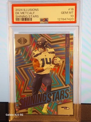 2024 Illusions DK Metcalf Shining Stars - Samlarkort från 2024 Illusions-serien med DK Metcalf från Seattle Seahawks. Kortet har färgstark holografisk design med texten 'Shining Stars' och är graderat PSA 10 GEM MT. Perfekt för NFL- och sportkortssamlare.