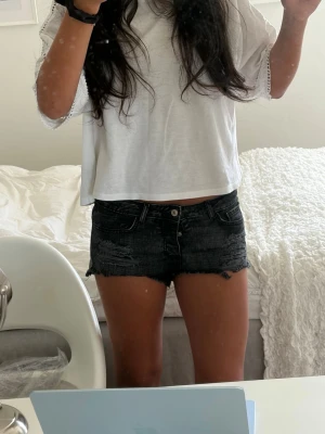 Snygga svarta slitna jeansshorts - Supercoola svarta jeansshorts i en snygg urtvättad nyans. Shortsen har rejäla slitna detaljer fram, råa fransade benslut och lätt slitna detaljer på bakfickorna. Klassisk 5-fickorsmodell som är perfekt till sommaren. Storlek 38 (alla mått finns i bilderna). Skickar snabbt!!💗