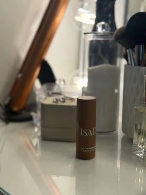 IsaDora bronzer stick Mocha, oöppnad! - Säljer ett IsaDora bronzer stick i färgen Mocha. Praktisk stiftform som gör det enkelt att applicera och skulptera ansiktet. Färgen är varm brun och passar perfekt för contouring. Smidig att ha med i väskan och enkel att använda.