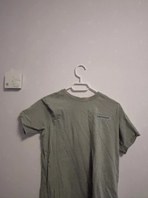 Grön t-shirt från Peak Performance - Snygg grön t-shirt från Peak Performance med diskret logga på bröstet. Klassisk rund halsringning och korta ärmar. Perfekt för en avslappnad och stilren look. Tillverkad i mjukt material som känns skönt mot huden.