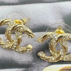 Elegant CC- örhängen  - Hög kvalitet, handgjorda logo örhängen ungefär 3X3 cm – varje detalj utstrålar en känsla av exklusiv elegans. Örhängena är tillverkade i allergivänliga material och har stift i 925 sterlingsilver, vilket gör dem bekväma och skonsamma att bära.  Designen är mer arbetad och detaljrik – lyxig men samtidigt elegant – perfekt för dig som uppskattar smycken med både finess och karaktär.  Levereras med en svart presentask och en presentpåse för en fulländad känsla.
