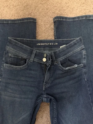 Lågmidjade jeans  - Blå lågmidjade bootcut jeans från Bikbok. I nyskick med fina fickor baktill.