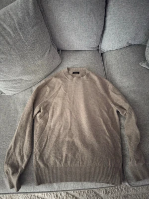 Kashmir från Massimo Dutti - Säljer en stilren beige Kashmir från Massimo Dutti. Tröjan har rund halsringning och ribbade muddar vid ärmslut och nederkant. Perfekt för dig som gillar en klassisk och enkel look.