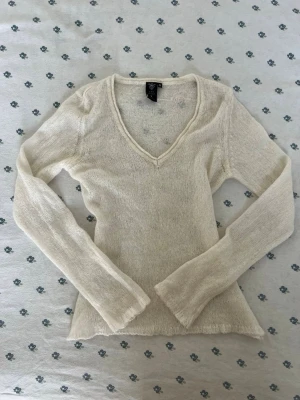 Vintage beige Eve of Eden stickad tröja - Autentisk vintage y2k 2000s tunnstickad beige / cream tröja från eve of Eden med v-ringad hals och långa ärmar. Tröjan har en figurnära passform och lätt transparent material, perfekt för lager på lager. Enkel och stilren design som passar till det mesta. Storlek M. Måtten finns. 