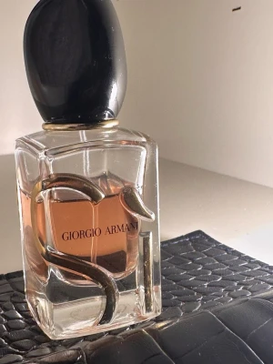 Giorgio Armani parfym - Giorgio Armani parfym, använd några gånger. 30 ml har den! Vid frågor hör av er!🩷 Detta är beskrivningen om den när det gäller doftnoter: Svartvinbärsnektar, modern cypress och ljus trämusk med inslag av doften av fresia och mairose. Denna parfym är gjord för den moderna kvinnan, som är stark och feminin, sofistikerad och karismatisk. Hon är kärnan i den smarta italienska elegansen och stilen. Pris kan diskuteras!