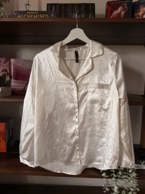Vit satinpyjamas || Hunkemöller  - Benvit satin överdel, säljes oanvänd och har bara legat ihopvikt i garderoben                                                     ⭐️Säljes i nyskick, utan defekter & slitage                                 💭Har du frågor? Skriv på annonsen och jag svarar så fort jag kan!