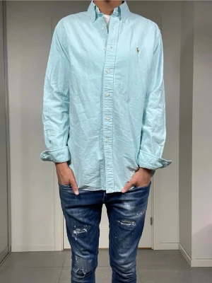 Ralph Lauren skjorta - Säljer denna raffe skjorta i utmärkt skick. Färgen är en snygg ljusblå som passar till avslappnade tillfällen samt fest. Skriv vid några frågor! Bvsa