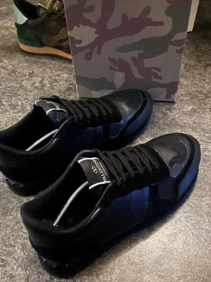 Svarta Valentino sneakers med camomönster - Säljer mina fräscha rockrunners för behöver inte dom längre eftersom jag införskaffat mig ett par andra skor, bara att höra av sig om mer info om de behövs. Kan även sänka priset vid snabb affär. 